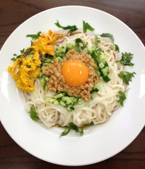 ひきわり納豆、かぼちゃサラダ、卵黄、きゅうり、大葉をのせた冷たいうどん