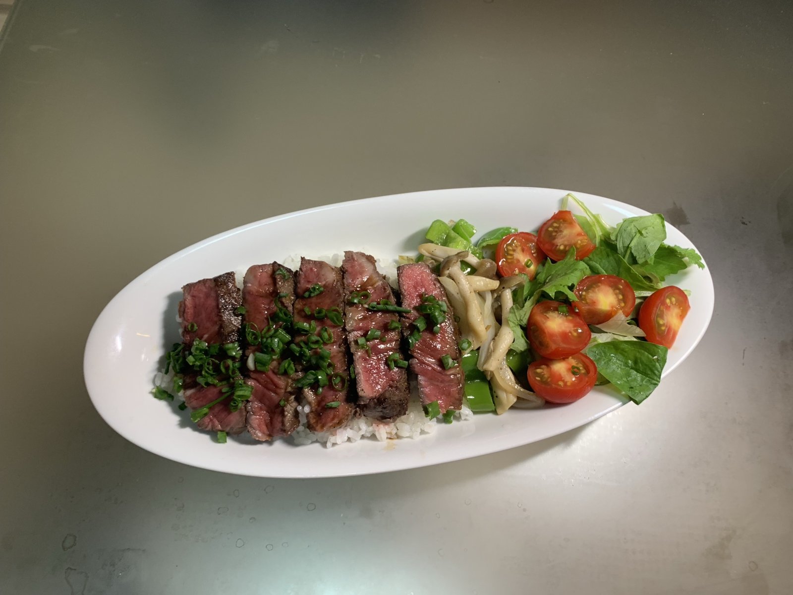 楕円の白い皿に盛った和牛ヒレのステーキ丼を真上から