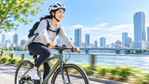 ヘルメットを着用し、川沿いを笑顔で自転車に乗る女性