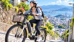 ヘルメットを着用し、港町の坂道で電動アシスト自転車に乗る女性